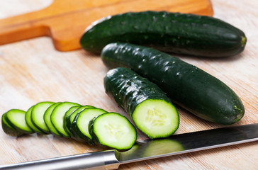 Whole and sliced fresh cucumbers