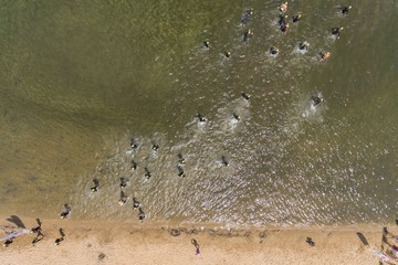 Triathlon swimming contest in lake swimmers competition aerial drone photo
