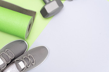 Yoga mat, sport shoes, apple, bottle of water on blue wooden background. Concept healthy lifestyle, healthy food, sport and diet. Sport equipment. Selective focus