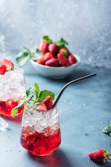 Red cocktail with ice and fresh strawberry