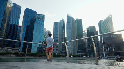 Traveller Looking At Singapore City Skyline and Bank Office Skyscrapers in Downtown