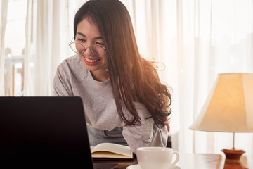 Young Asian woman is working at home. Freelancer is using phone for work. work at home concept.