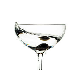 Martini and green olive isolated on white .