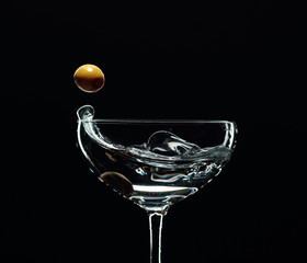 Silhouette of martini with green olives.