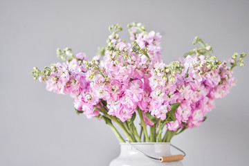Bouquet of Beautiful lilac mattiola. Spring flowers in vase on wooden table. Flowers delivery.