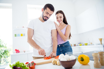 Photo of idyllic two people prepare tasty organic dish kitchen man cut vitamins pepper chopping board woman enjoy chef help look in weekend lifestyle house indoors