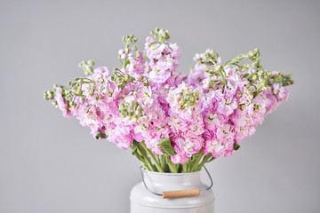 Bouquet of Beautiful lilac mattiola. Spring flowers in vase on wooden table. Flowers delivery.