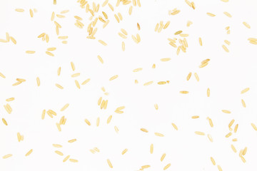 Close-up of brown long-grain rice arranged in a chaotic order on a white background.