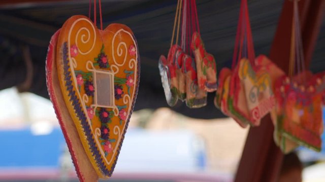 Licitars hearts and gingerbread in the shape of a horse hanging below the festivals tent. Sweets in bags at a street sale. 