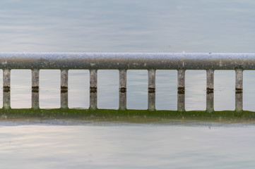 View of a quarry pond with a special focus on a reflective marking for non-swimmers from the shore with cloudy skies and calm water in northern Germany