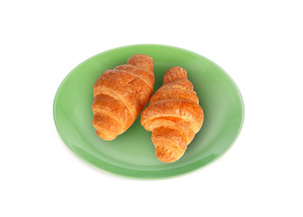 croissant in the green plate isolated on white background