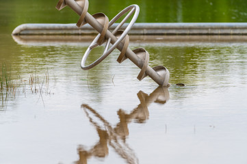 view of an excavated lake with a special focus on a reflective toy for children that can carry water from the shore with overcast skies and calm water in northern Germany