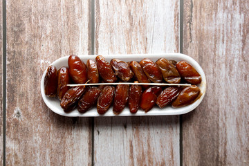 Oval Box of Dates on wooden background, selective focus