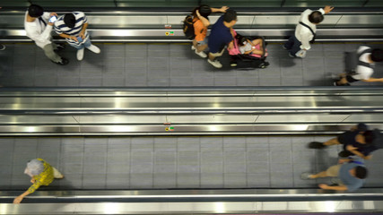 Anonymous Travellers On Moving Walkway at Airport