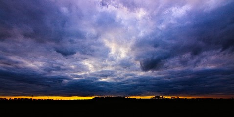 Stalowe chmury o zachodzie słońca - obrazy, fototapety, plakaty