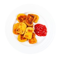 top view of many fried chicken nuggets with tomato ketchup on white plate isolated on white background
