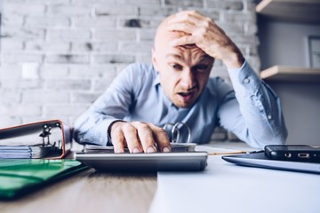 Crying businessman stressed about bankruptcy debt.