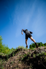 
young adult sports guy trail runner practicing sunny day in the mountains