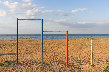 Large multi-colored turnstiles stand on the beach with clean blue sky. 