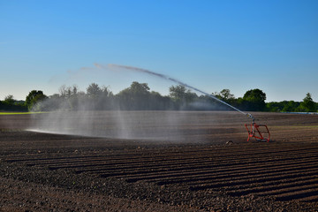 Artificial watering of a field due to dryness.