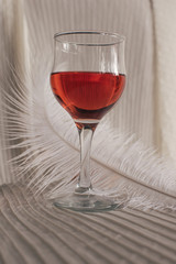 A tender morning, vintage mood. A glass of wine and a jewelry box next to a feather