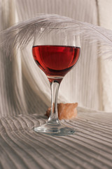 A tender morning, vintage mood. A glass of wine and a jewelry box next to a feather