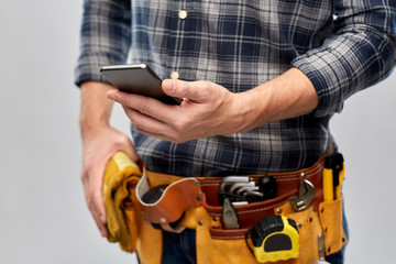 repair, construction and building - male worker or builder with smartphone and working tools on...