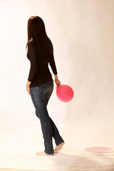 A young girl holding an isolated red balloon on a white background