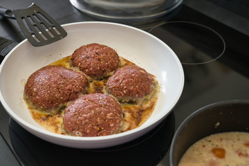 Frikadellen Gemüse Fleisch Paddys mit Kurkuma beim Anbraten in weißer Teflonpfanne mit Kokosöl, Produktbild