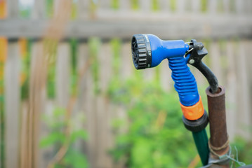 A garden sprinkler on the garden fence background close up.