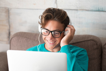Young and cheerful happy teenager in video conference chat on laptop computer at home - lockdown or student with smart internet technology - studying with modern device not at school online. life