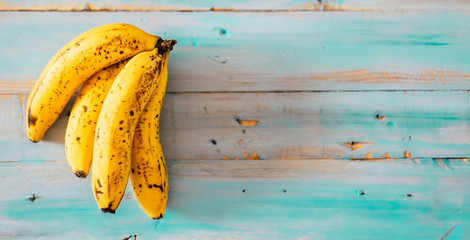 Fresh and tasty natural banana fruit on blue trendy wooden old table - healthy food and vitamins concept background © simona