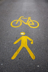 Swiss yellow reflective road marking indicating a bicycle path and a pedestrian walkway at the same time.