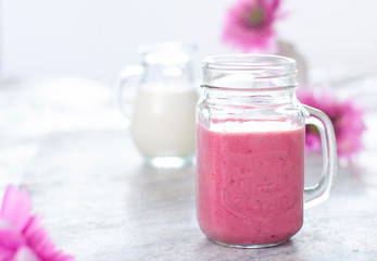 Beautiful light fruit smoothie in the glass with white and pink colors. Berries drink. Milk natural organic products
