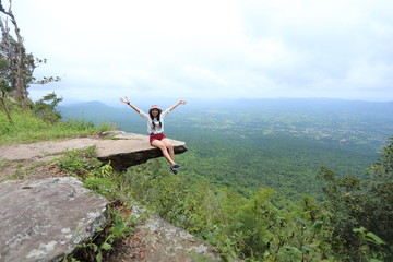 Fototapeta premium Woman sitting at the edge of a cliff Sai Thong National Park in Chaiyaphum, Thailand.