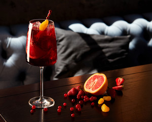 Glass of aperol spritz cocktail on wooden table in cafe