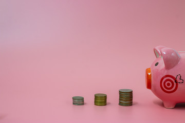 Pink piggy bank and coins on pastel pink background, Financial concepts