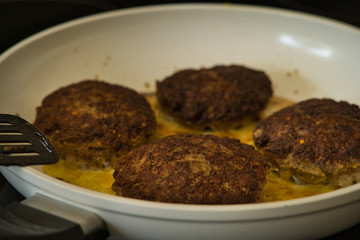 Frikadellen Gemüse Fleisch Paddys mit Kurkuma beim Anbraten in weißer Teflonpfanne mit Kokosöl, Produktbild