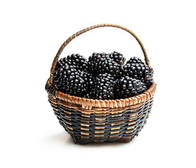 Fototapeta na wymiar Small wicker basket full of fresh blackberries isolated on white