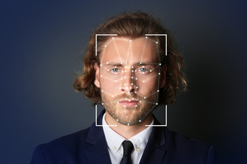 Facial recognition system. Businessman with scanner frame and digital biometric grid on dark...