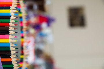 Colored pencils arranged in a row and in a circle . close up of colorful set wooden color pencil in isolated black and blur background.Colorful colored pencils on blurred bokeh background .