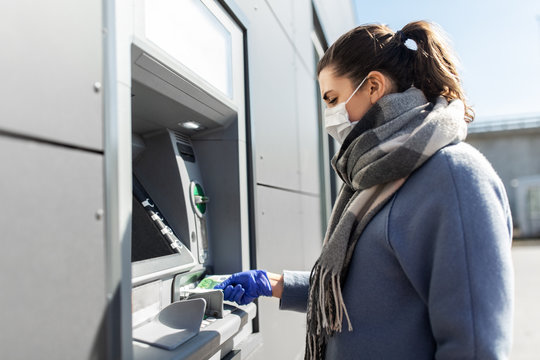 finance, bank and hygiene concept - woman in medical mask and glove with cash money at atm machine