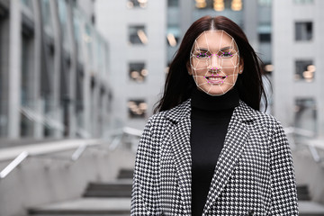Facial recognition system. Mature woman with digital biometric grid, outdoors
