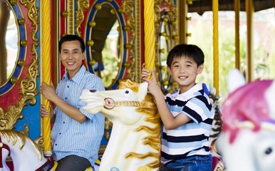 Father and son on a carousel © ImageHit