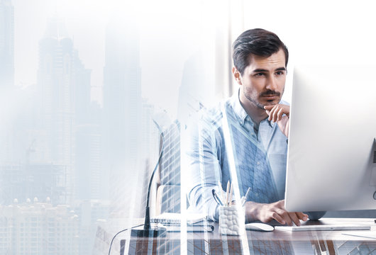 Multiple exposure of architect working with computer at table and buildings