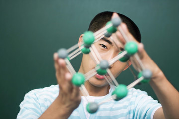 Young man holding molecular structure