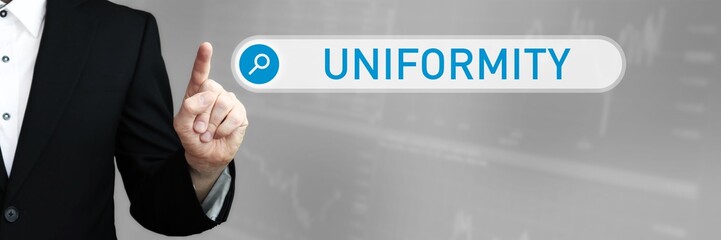 Uniformity. Businessman (Man) in a suit pointing with his finger to a search box. The word is in focus. Blue Background. Business, Finance, Statistics, Analysis, Economy