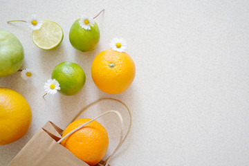 Healthy food in a kraft paper bag. Zero waste concept, reusable eco pack. Mix of different fruits and flowers on a white background, shopping packaging, top view, flatlay
