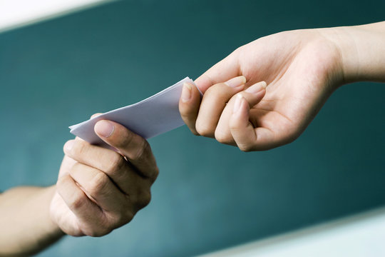 Hands Passing A Note