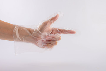 Hand wearing disposable protective plastic glove on a white background.